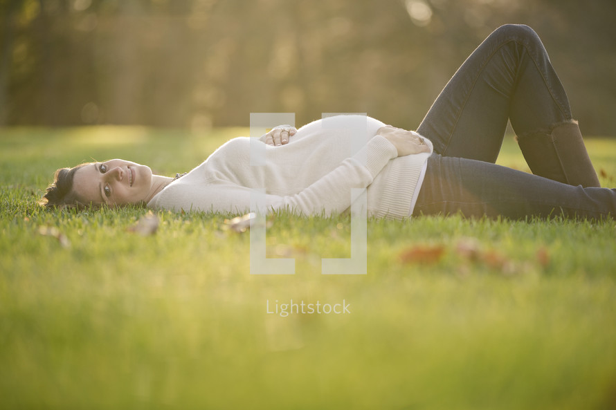 pregnant woman lying in the grass