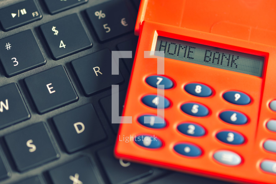 Home bank written on the display of the digipass over computer keyboard. Online banking transaction concept