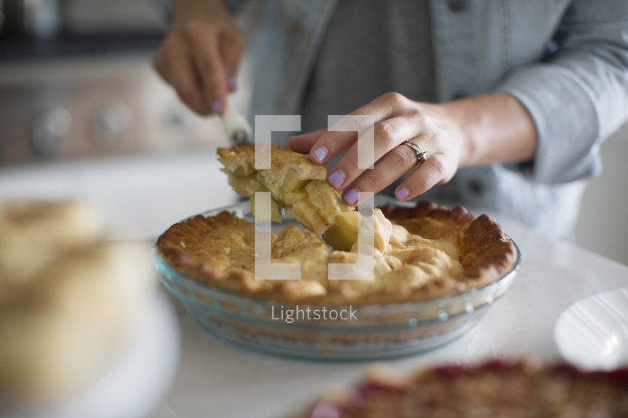 a woman cutting a slice of apple pie