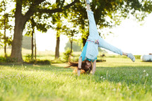 a girl doing cartwheels in the grass