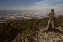 a man standing on a mountaintop taking in the view