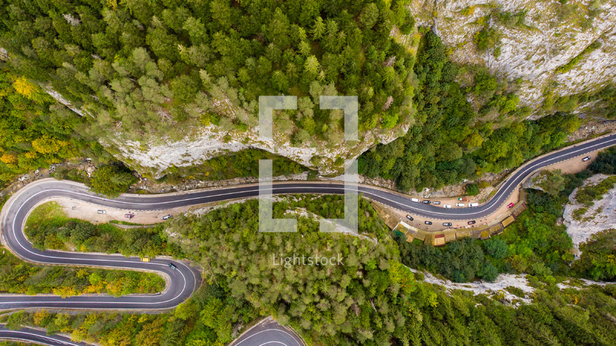Aerial drone footage of winding road through green trees