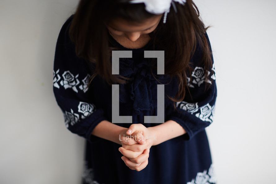 girl with head bowed in prayer