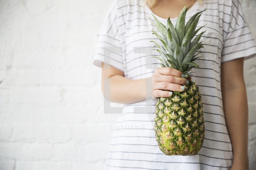 woman holding a pineapple 