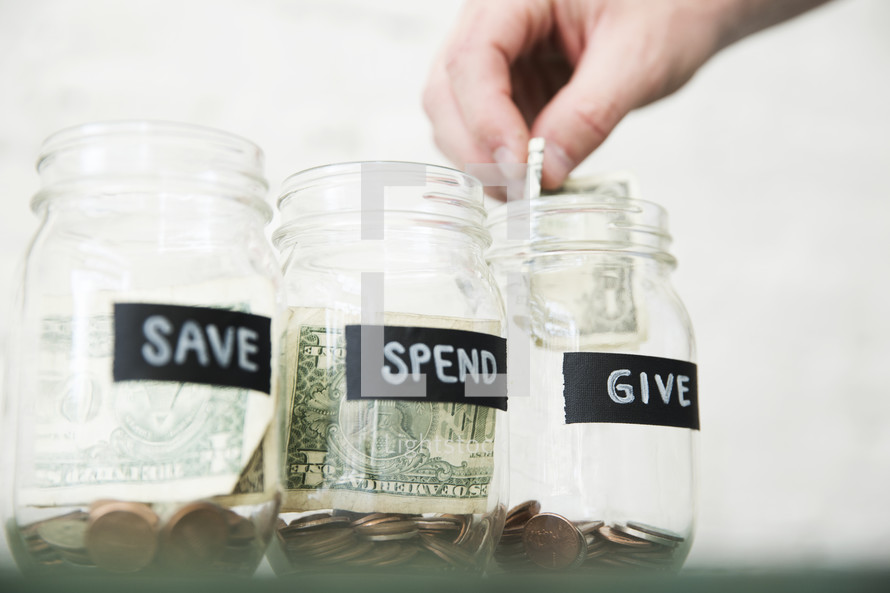 placing money in Give, Save, Spend money jars