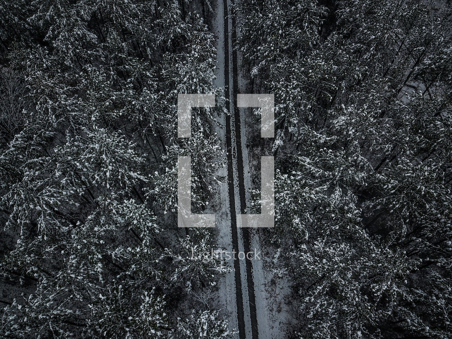 aerial view over tire tracks in snow on a road 