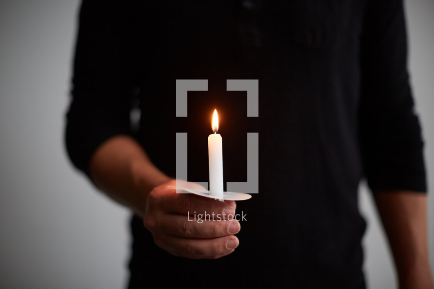 a man holding a candle 