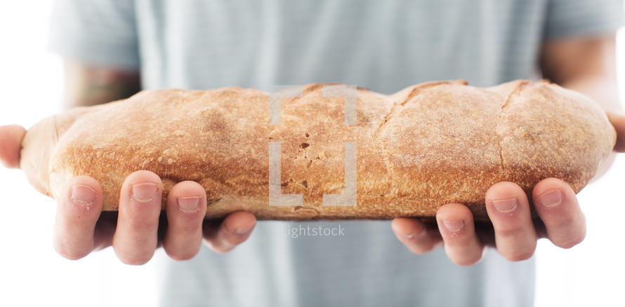 man holding a loaf of bread 