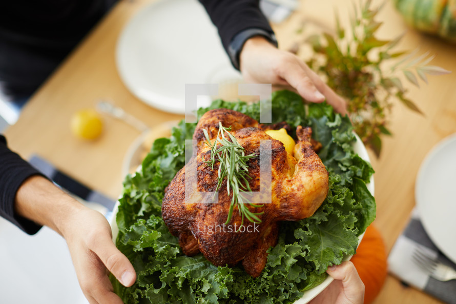 a man putting the Thanksgiving turkey on the table 