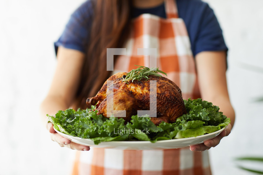 a woman holding a Thanksgiving turkey 