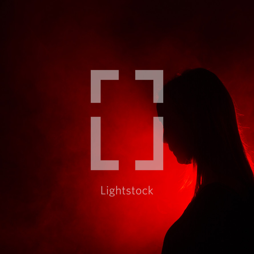 silhouette of a woman standing in red light 