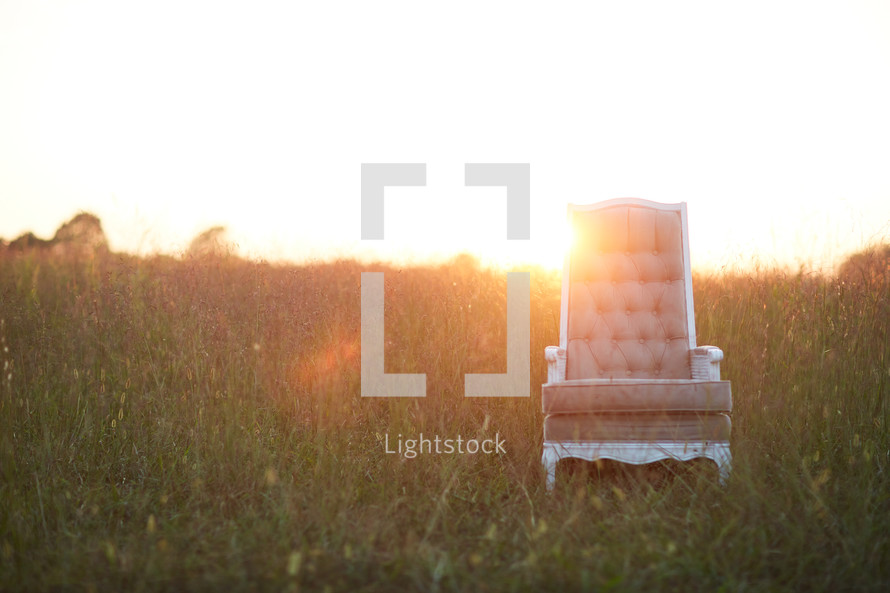 empty chair in a field of tall grass