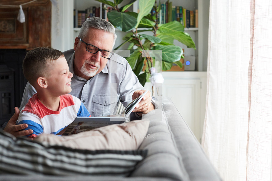 grandfather reading a book to his grandson