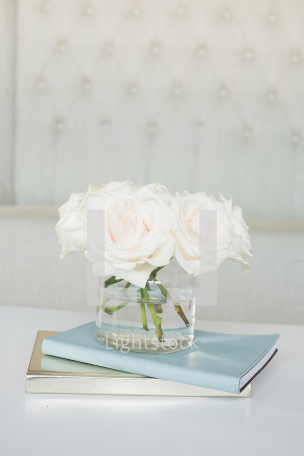 roses in a vase on journals 