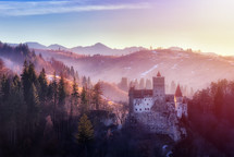 Bran or Dracula Castle in Transylvania, Romania. The castle is located on top of a mountain, sunset light
