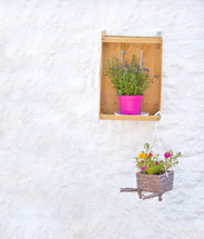 Flowers and baskets against white painted brick wall in Alberobello italy