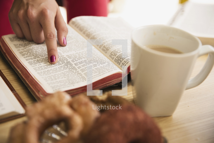 woman pointing to scripture and a coffee mug