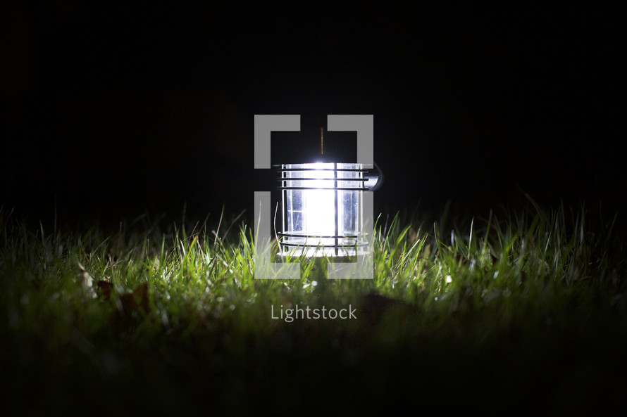 a glowing lantern in the grass 