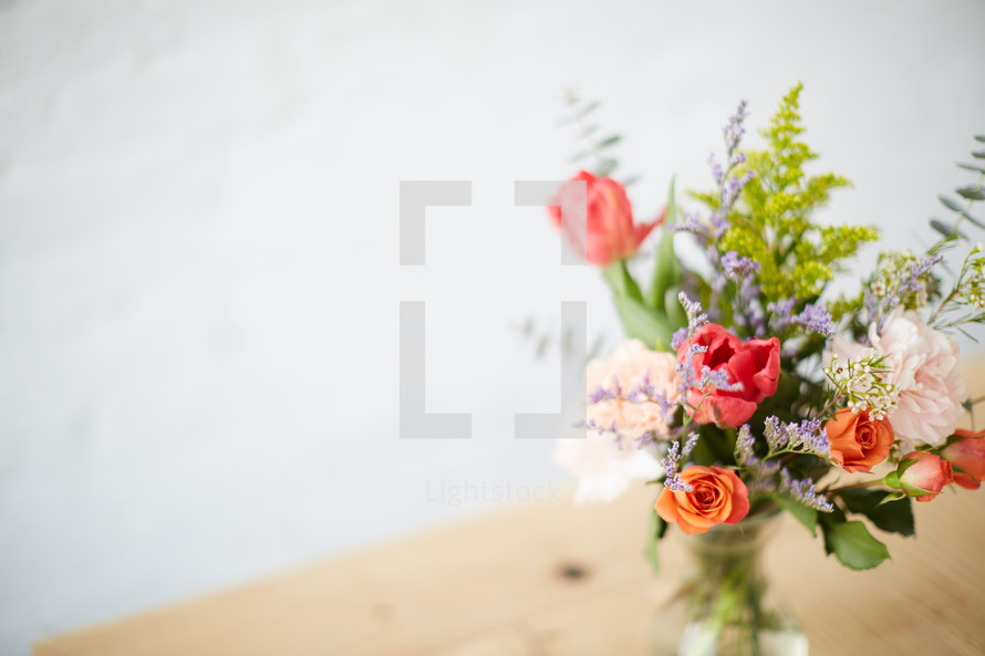 vase of flowers on a wood table 