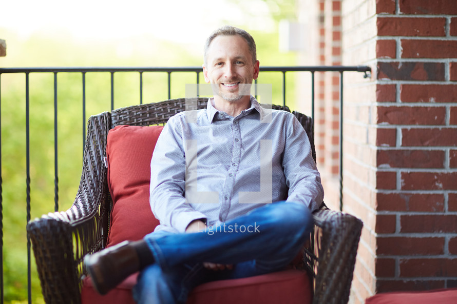 a man sitting on a porch relaxing 