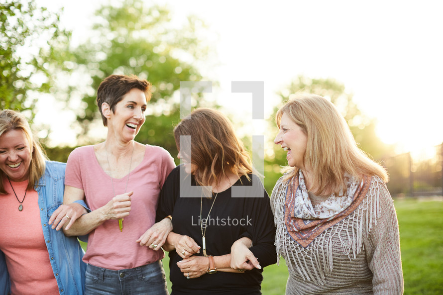 women standing in a backyard talking 