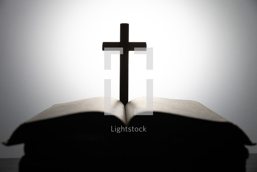 Glowing white light over a Bible with a cross