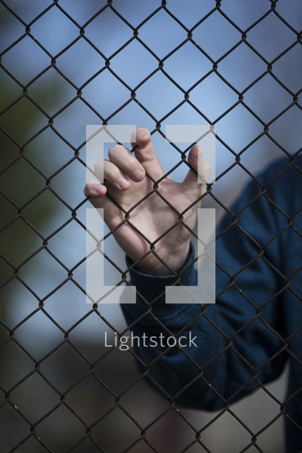 hand on a chain link fence 