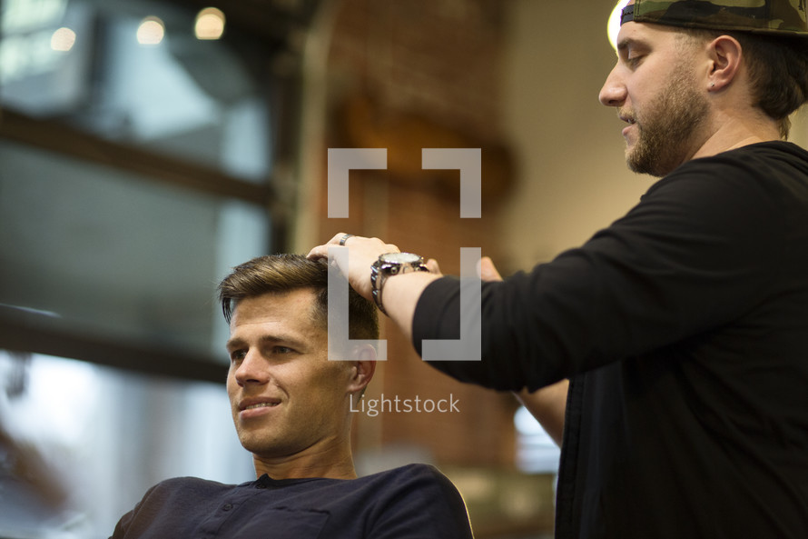a man getting a haircut at a barber shop 