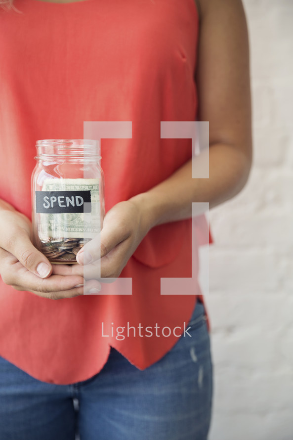 woman holding a spending jar 