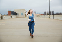 teen girl running through a parking deck 