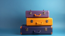 Purple, yellow, and navy suitcases on a blue background. Travel concept. 