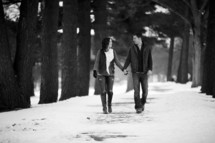 man and woman walking holding in the snow 