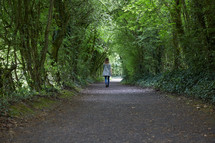 a woman walking down a path 
