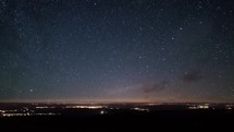 Starry night sky with stars time lapse motion over countryside traffic astronomy
