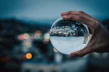 person holding an orb with a view of suburbs 