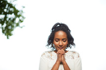 an African American woman praying outdoors 