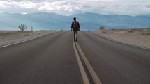 a man walking on a desert highway 