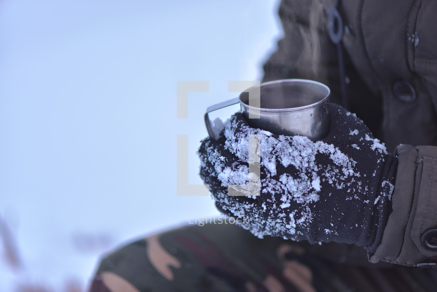Side view of male hand in gloves holding cup with hot tea or coffee. Tea break. Winter time concept