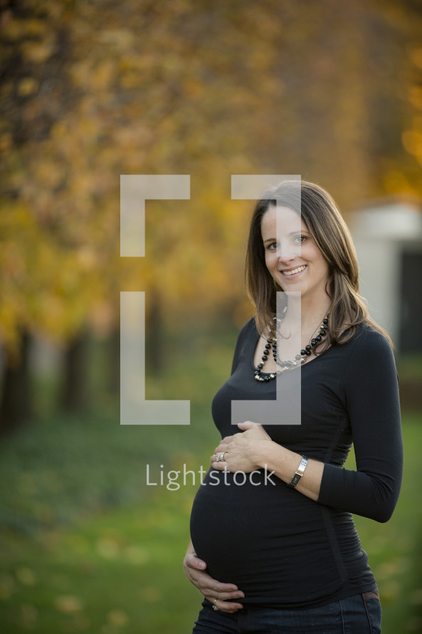 smiling pregnant woman with her hands on her belly