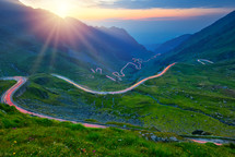 Traffic trails on Transfagarasan pass at sunset. Crossing Carpathian mountains in Romania