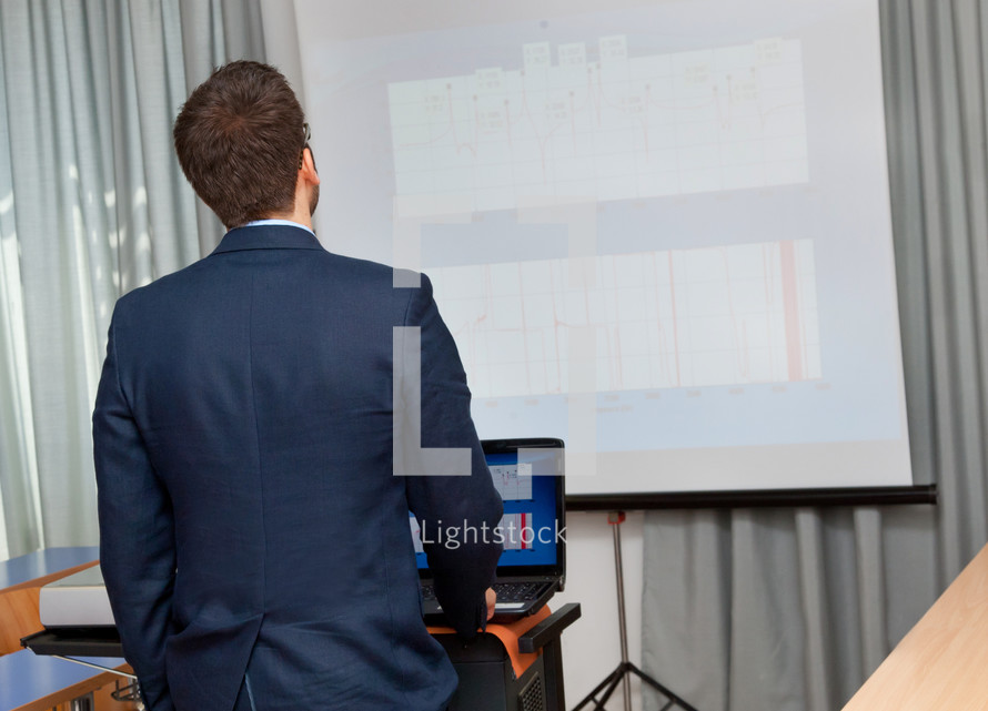 Businessman shows a project with notebook and projector.