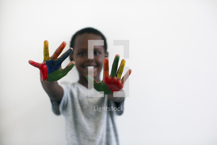 a little boy with rainbow painted hands 
