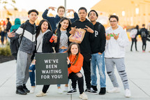 group of teens with a we've been waiting for you sign 