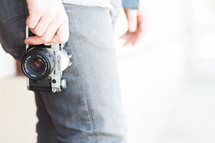 man holding a camera at his side 