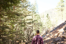 a man walking in a mountain forest 
