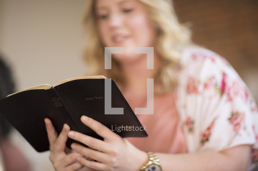 a woman reading a Bible at a Bible study group 