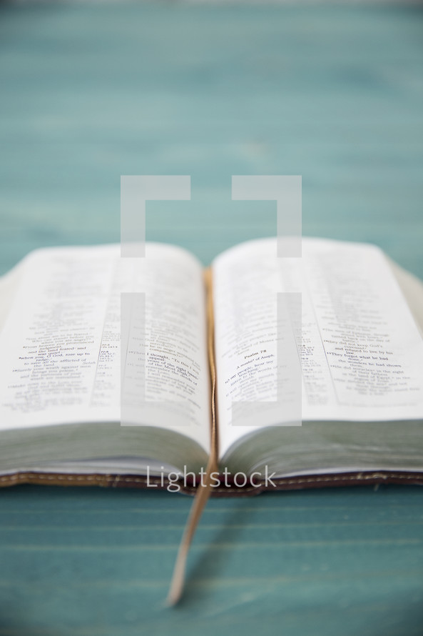 An open Bible on a wooden table.