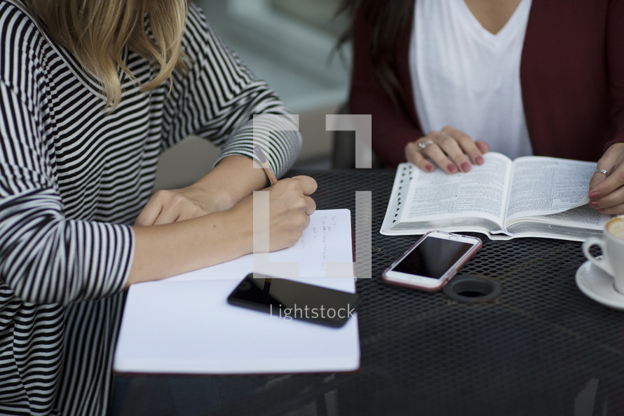 young women reading a Bible and discussing scripture 