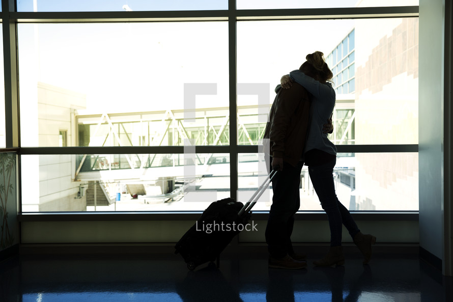 couple hugging at an airport 