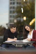 a young man and young woman reading a Bible and discussing scripture 